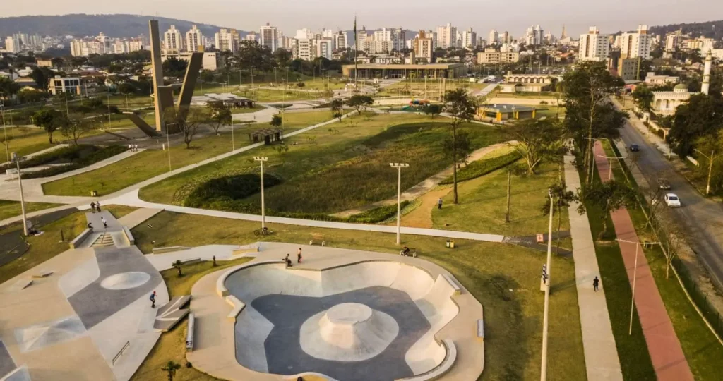 Imagem de praça em Criciúma com prédios e vegetação ao fundo para ilustrar matéria sobre as cidades do interior de Santa Catarina
