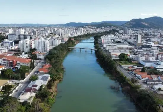 Imagem panorâmica de um rio cercado por prédios em Tubarão para ilustrar matéria sobre o interior de Santa Catarina