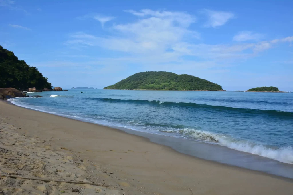 Imagem da Praia do Prumirim, em Ubatuba, mostra mar, vegetação e faixa de areia em um dia ensolarado para ilustrar matéria sobre as melhores praias do litoral de São Paulo