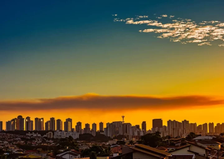 Imagem de prédios e casas com um pôr do sol ao fundo em Ribeirão Preto para ilustrar matéria sobre qual a cidade mais quente do estado de São Paulo