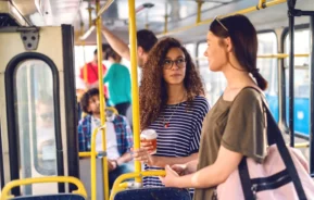 Imagem de duas mulheres conversando em um ônibus para ilustrar matéria sobre os terminais de ônibus em SP