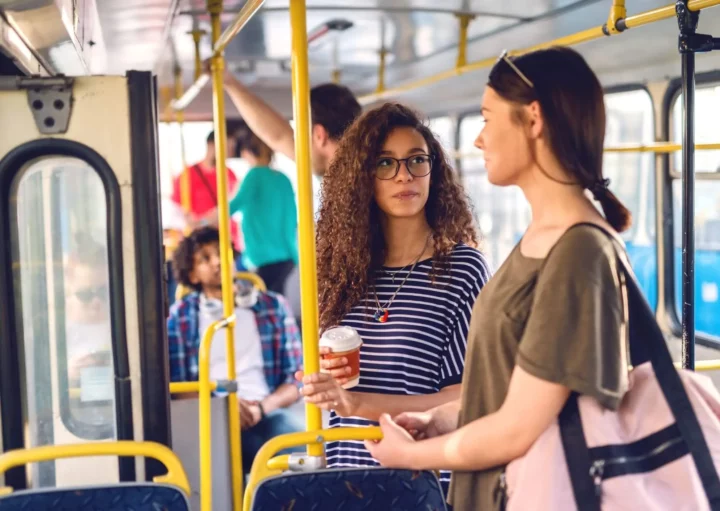 Imagem de duas mulheres conversando em um ônibus para ilustrar matéria sobre os terminais de ônibus em SP