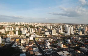 Foto que ilustra matéria sobre cidades do Triângulo Mineiro mostra o município de Uberlândia visto do alto em um dia de céu azul e algumas poucas nuvens ao fundo. (Foto: Shutterstock)