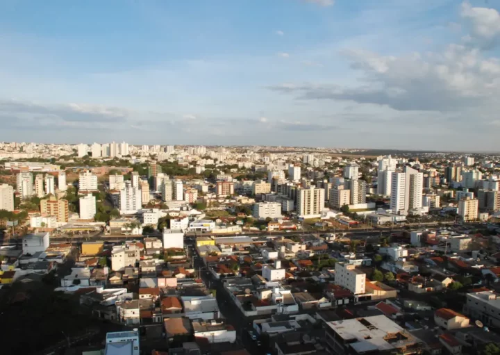 Foto que ilustra matéria sobre cidades do Triângulo Mineiro mostra o município de Uberlândia visto do alto em um dia de céu azul e algumas poucas nuvens ao fundo. (Foto: Shutterstock)