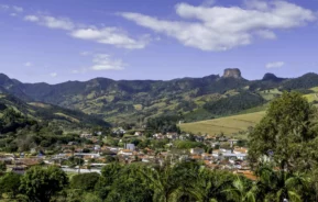 Imagem da vista aérea de Campos do Jordão, em São Paulo, mostra prédios e casas da cidade cercados por montanhas e vegetação para ilustrar matéria sobre as cidades mais altas do Brasil