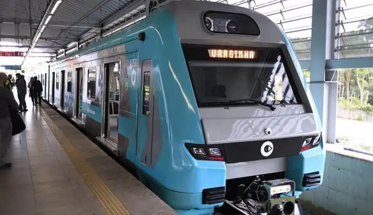 Imagem de um trem azul da Linha 9-Esmeralda na estação com o letreiro sinalizando a estação Varginha para ilustrar matéria sobre a Linha 9-Esmeralda agora.