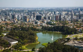 Imagem da vista aérea de São Paulo mostra lago e vegetação do Parque Ibirapuera, além de prédios ao redor, para ilustrar matéria sobre o que fazer na Zona Sul de SP