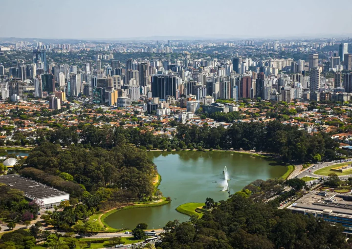 Imagem da vista aérea de São Paulo mostra lago e vegetação do Parque Ibirapuera, além de prédios ao redor, para ilustrar matéria sobre o que fazer na Zona Sul de SP