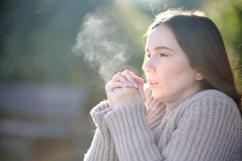 Imagem de mulher respirando frio e agasalhada no inverno para ilustrar matéria sobre quais são as cidades mais frias do Nordeste