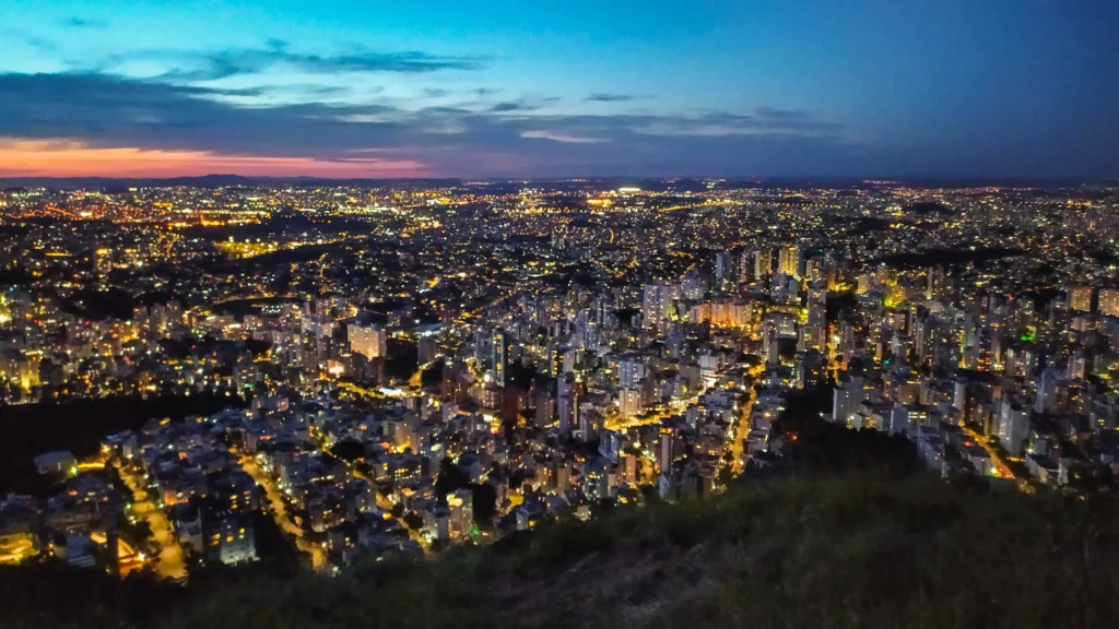 Imagem da vista aérea do bairro Buritis, em Belo Horizonte, mostra pôr do sol na cidade visto da montanha para ilustrar matéria sobre quais são os bairros da Zona Oeste de BH