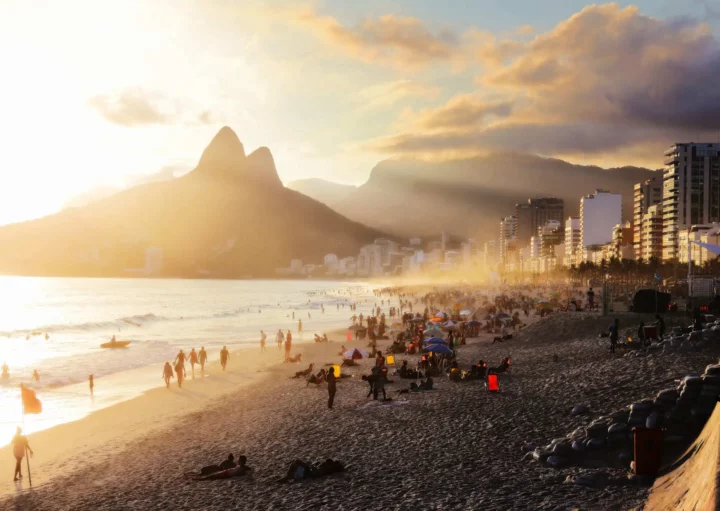 Imagem de pessoas aproveitando a praia de Ipanema em um dia de sol para ilustrar matéria sobre os bairros mais quentes do Rio de Janeiro