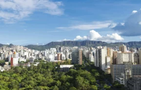 Imagem de Belo Horizonte mostra prédios, árvores e morros ao fundo para ilustrar matéria sobre a cidade mais arborizada do Brasil