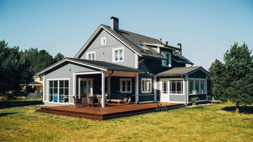 Imagem de uma casa moderna de dois andares em um lote grande com grama e árvores para ilustrar matéria sobre o que é penhora de imóvel