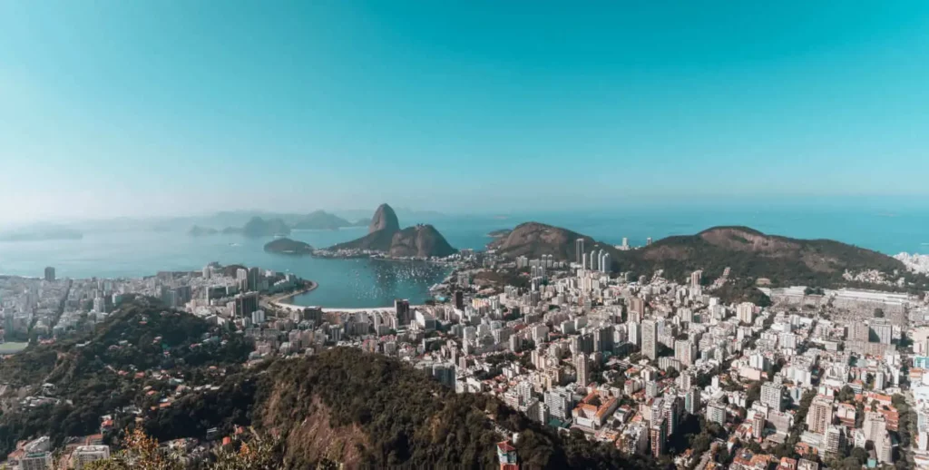 Imagem da vista aérea da cidade do Rio de Janeiro mostra prédios, montanhas e o Pão de Açúcar ao fundo para ilustrar matéria sobre o bairro com mais moradores no Rio de Janeiro