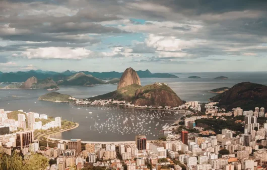 Imagem da vista aérea da cidade do Rio de Janeiro mostra o Pão de Açúcar, mar e prédios em um dia de céu azul para ilustrar matéria sobre os bairros mais populosos do Rio de Janeiro