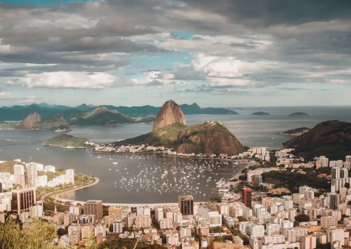 Imagem da vista aérea da cidade do Rio de Janeiro mostra o Pão de Açúcar, mar e prédios em um dia de céu azul para ilustrar matéria sobre os bairros mais populosos do Rio de Janeiro