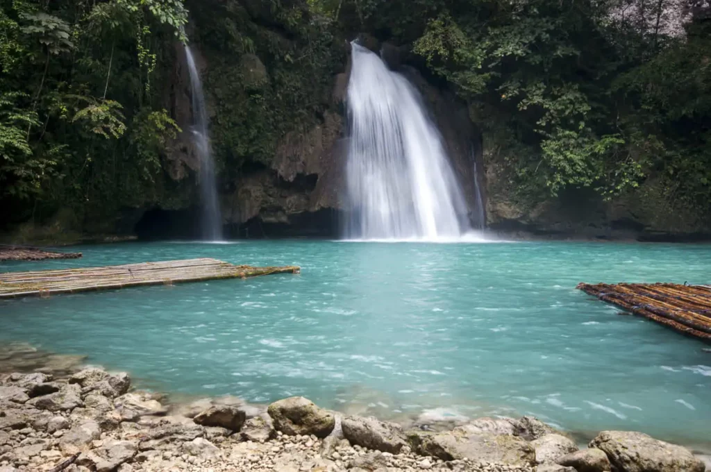 Imagem de uma cachoeira com queda de água pequena e um poço azul cristalino para ilustrar matéria sobre cachoeira em SP