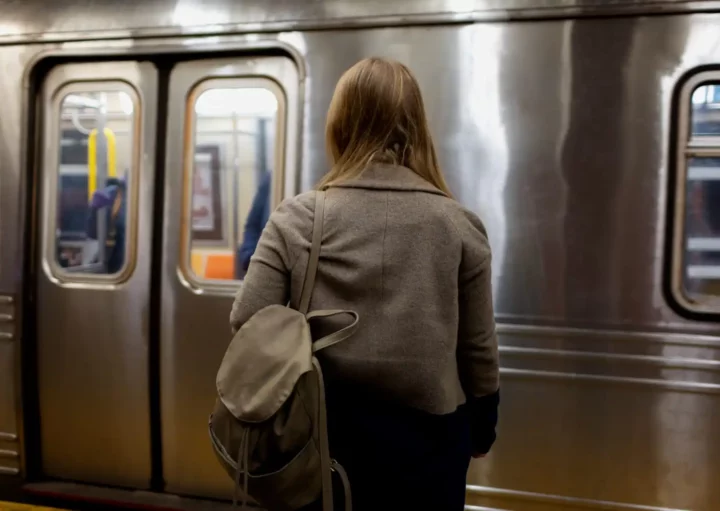 Imagem de uma mulher de costas com uma mochila pendurada nos ombros em frente a um trem em uma estação de metro para ilustrar matéria sobre a Linha 15-Prata