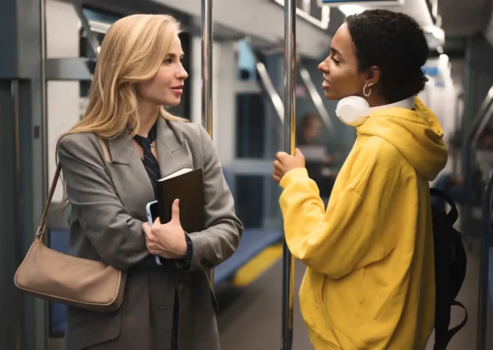 Imagem de duas mulheres paradas em pé uma em frente da outra dentro de um trem do metrô para ilustrar matéria sobre a Linha 5-Lilás, de São Paulo