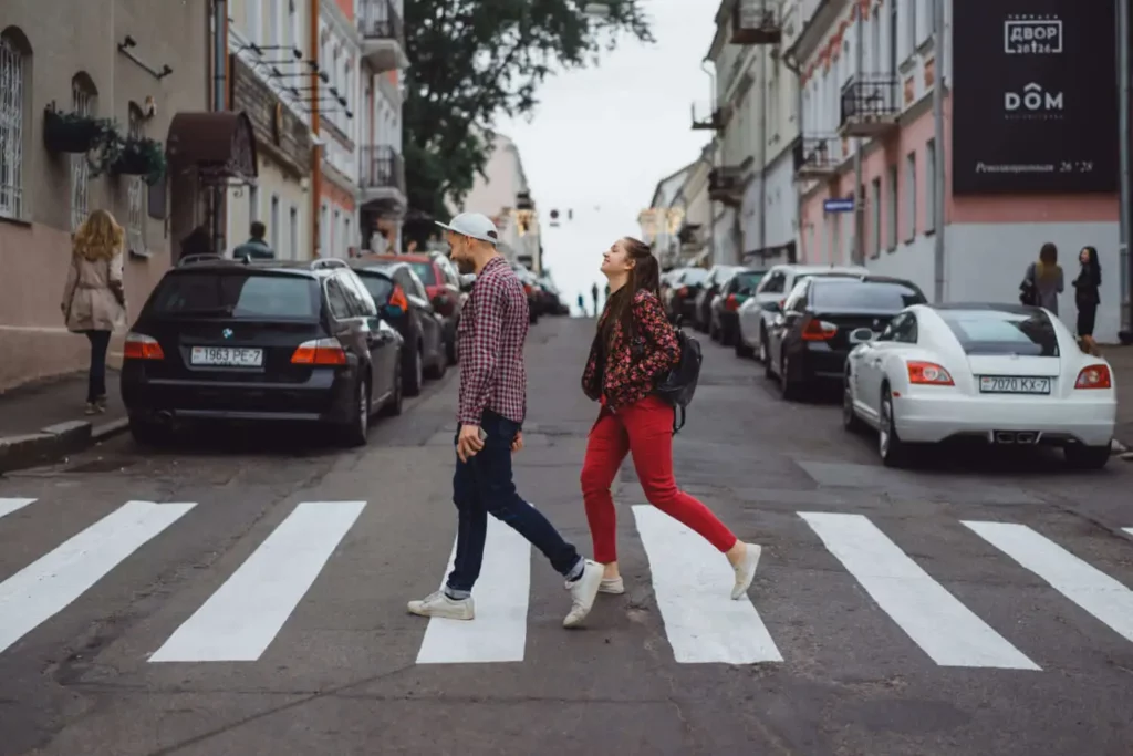 Imagem de um homem e uma mulher atravessando a faixa de pedestre em um bairro para ilustrar matéria sobre os bairros baratos de Florianópolis para morar