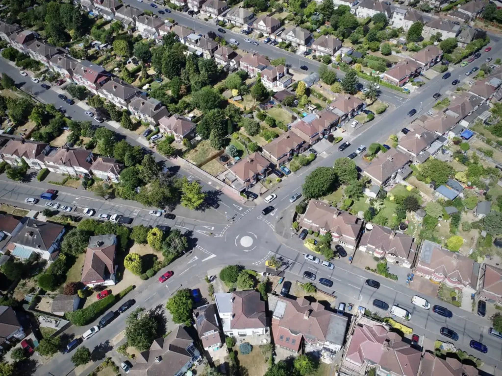 Imagem aérea de um bairro residencial com vista para as vias, casas e árvores ao redor para ilustrar matéria sobre infraestrutura de bairro