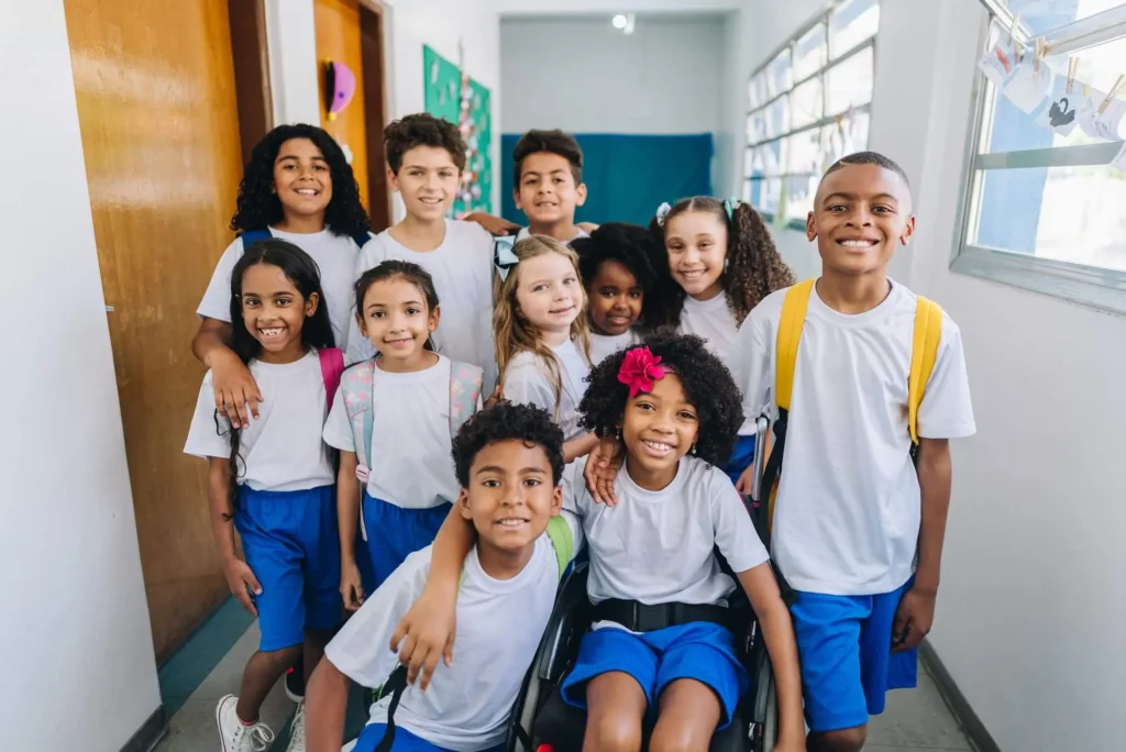 Imagem de uma turma de alunos formada por meninos e meninas de uniforme no corredor de um colégio para ilustrar matéria sobre a melhor escola em Nilópolis