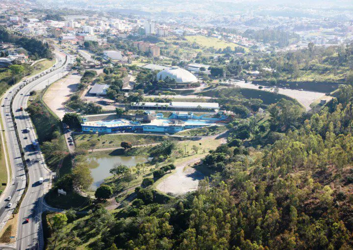 Imagem da vista aérea de Vinhedo mostra vegetação, lago, avenidas e construções da cidade para ilustrar matéria sobre os melhores bairros de Vinhedo