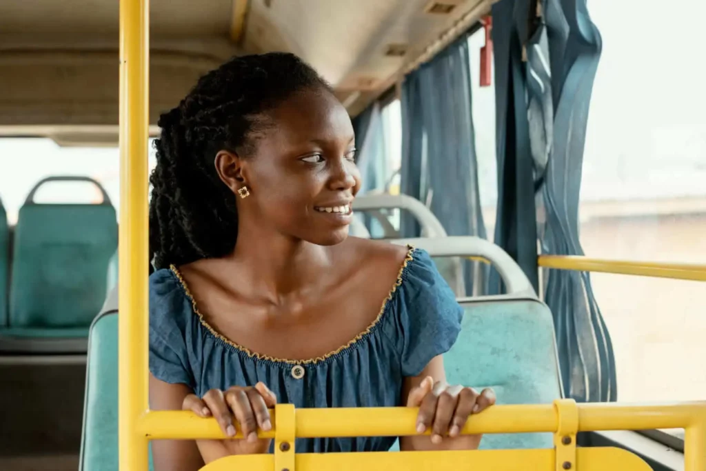 Imagem de uma mulher com tranças no cabelo sentada na cadeira de um ônibus para ilustrar matéria sobre os melhores bairros de Nilópolis