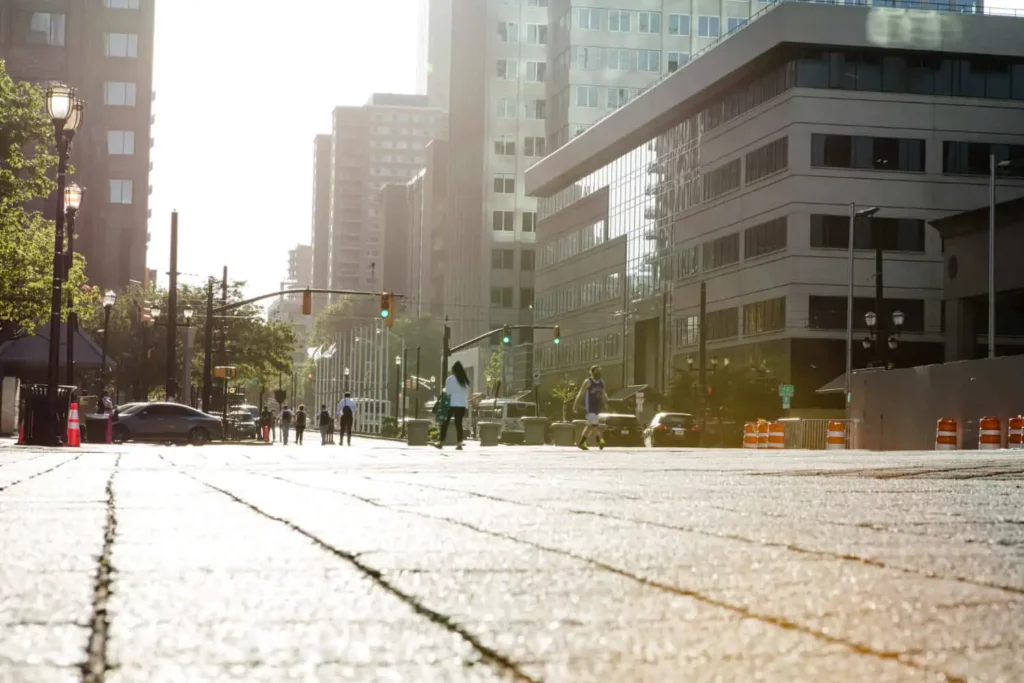 Imagem tirada de baixo para cima com vista para o asfalto, prédios corporativos, pedestres e carros para ilustrar matéria sobre tipos de infraestrutura de um bairro