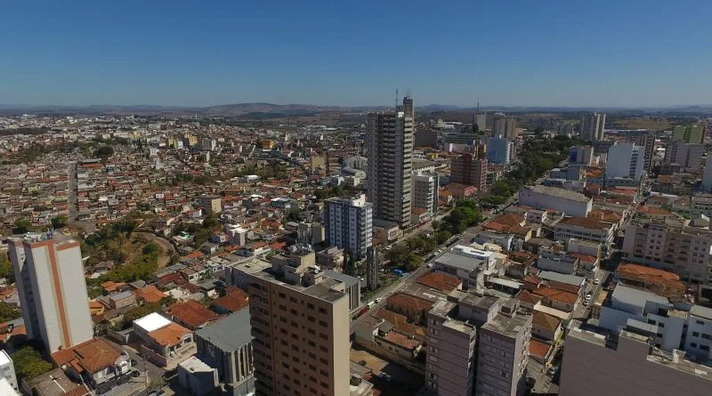 Imagem da vista aérea da cidade de Varginha, em Minas Gerais, mostra prédios, telhados de casas, avenidas e vegetação