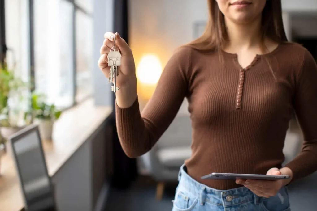 Imagem de uma mulher segurando um tablet as chaves de um imóvel para ilustrar matéria sobre assinei uma proposta de compra de imóvel e desisti, e agora?