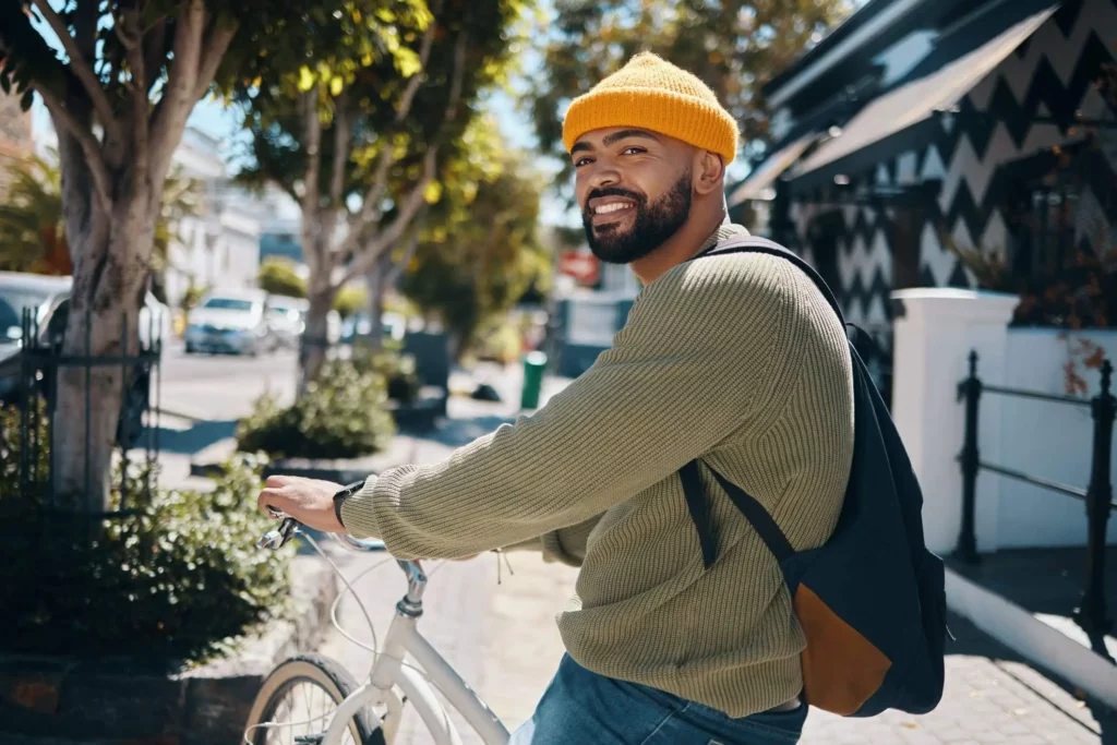 Imagem de um homem em cima de uma bicicleta em meio à cidade para ilustrar matéria sobre as cidades do futuro no Brasil
