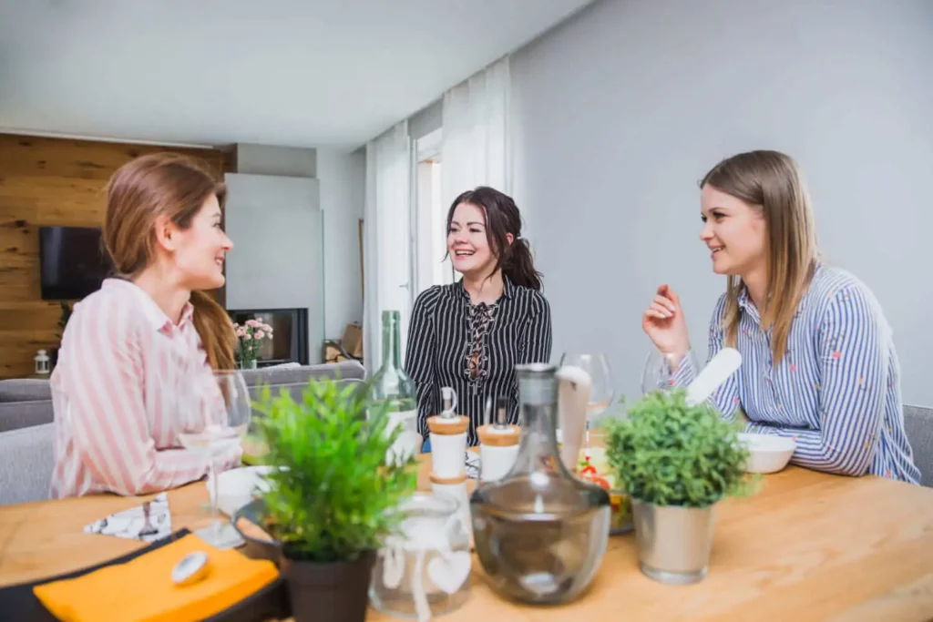 Imagem de três mulheres sentadas ao redor da mesa de um imóvel enquanto conversam para ilustrar matéria sobre o que fazer quando um dos herdeiros não quer vender o imóvel