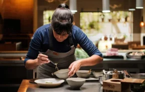 Foto que ilustra matéria sobre os melhores restaurantes de Curitiba mostra a chef Manu Buffara montando um prato em seu restaurante Manu (Foto: Divulgação)