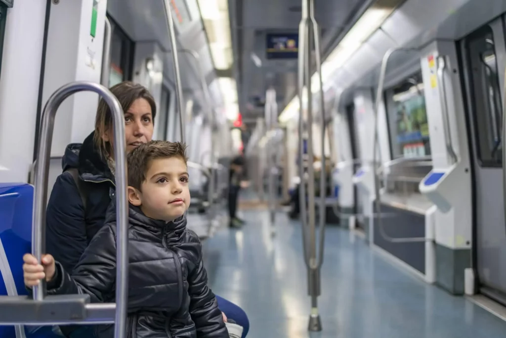 Imagem de uma mãe e uma criança sentados no banco de um vagão do metrô para ilustrar matéria sobre como é morar perto do metrô