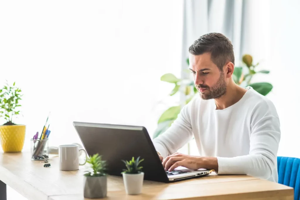 Imagem de um homem concentrado teclando no computador para ilustrar matéria sobre comprovante de aluguel