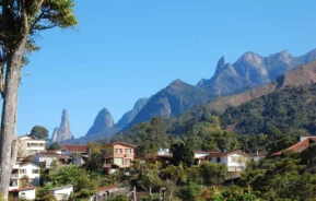 Imagem da vista de montanhas, casas e vegetação de Teresópolis, no Rio de Janeiro, para ilustrar matéria sobre as melhores cidades do interior do Rio de Janeiro