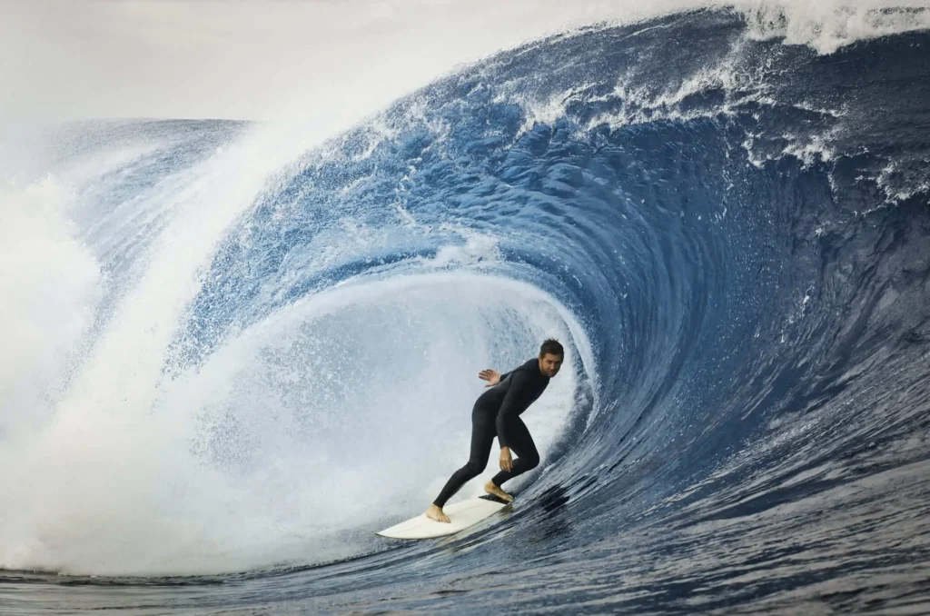 Imagem de surfista pegando onda em mar para ilustrar matéria sobre o interior do RJ