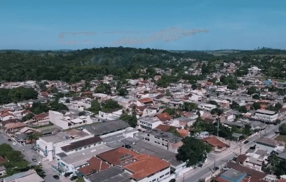 Imagem da vista aérea de Silva Jardim, no interior do RJ, mostra casas e vegetação da cidade em um dia de céu azul