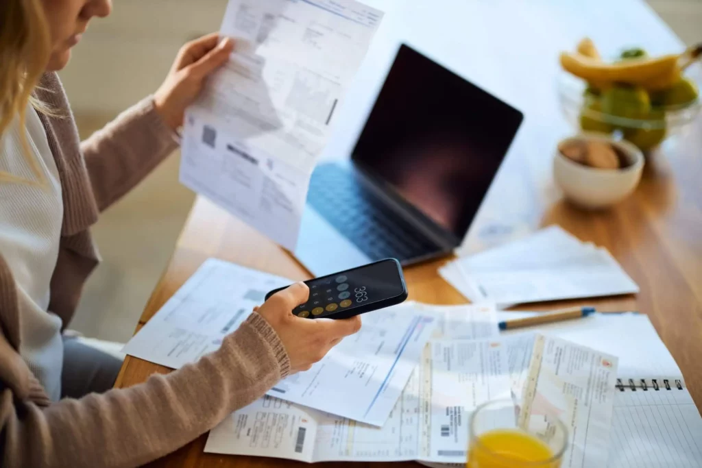 Imagem de uma mulher fazendo contas na calculadora do celular para ilustrar matéria sobre como é calculado o IPTU em Goiânia