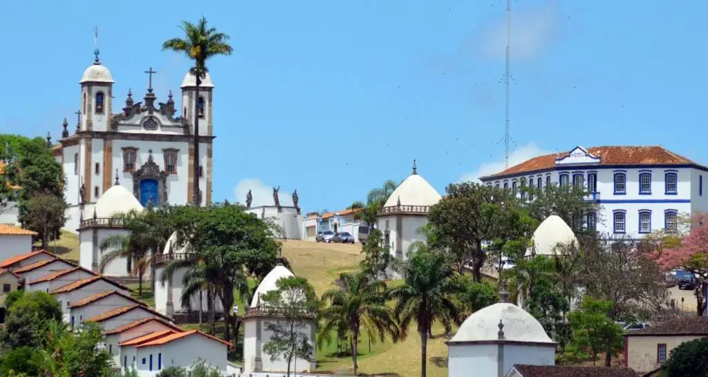 Imagem da vista aérea da cidade de Congonhas mostra casas, igreja e vegetação para ilustrar matéria sobre as cidades históricas de Minas Gerais perto de BH