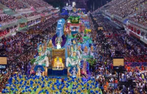 Imagem do desfile das escolas de samba no Sambódromo de Rio de Janeiro mostra carro alegórico, dançarinos e público nas arquibancadas para ilustrar matéria sobre como é comemorado o carnaval nas cidades grandes