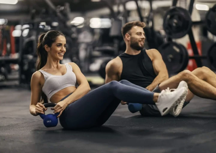 Imagem de um casal formado por um homem e uma mulher fazendo academia juntos para ilustrar matéria sobre as academias em São Paulo