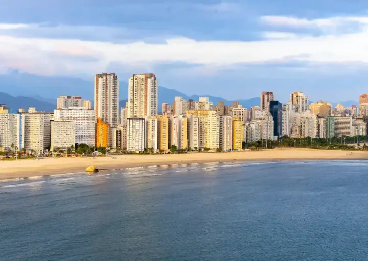 Imagem da vista de São Vicente mostra mar, faixa de areia e prédios ao fundo para ilustrar matéria sobre bairro de São Vicente
