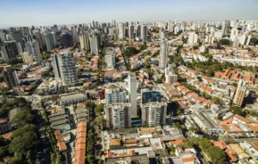 Imagem da vista aérea da Vila Mariana, em São Paulo, mostra casas, prédios e vegetação do bairro em um dia de céu azul para ilustrar matéria sobre os bares na Vila Mariana