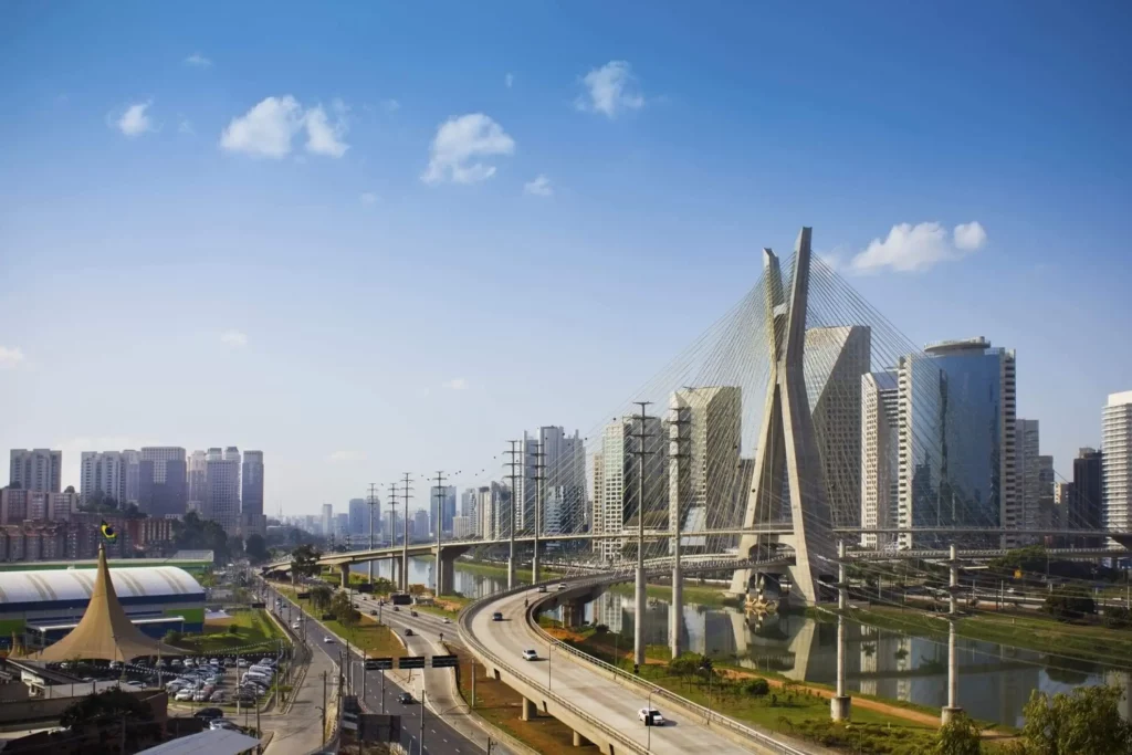 Imagem da vista urbana da capital paulista mostra avenidas, prédios e a Ponte Estaiada em um dia de céu azul