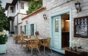 Imagem de mesas e cadeiras dispostas no lado externo de um restaurante para ilustrar matéria sobre restaurantes aconchegantes