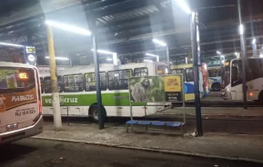 Vários ônibus estão estacionados na parte coberta do Terminal Rodoviário de Duque de Caxias à noite (Foto: Wikimedia Commons)
