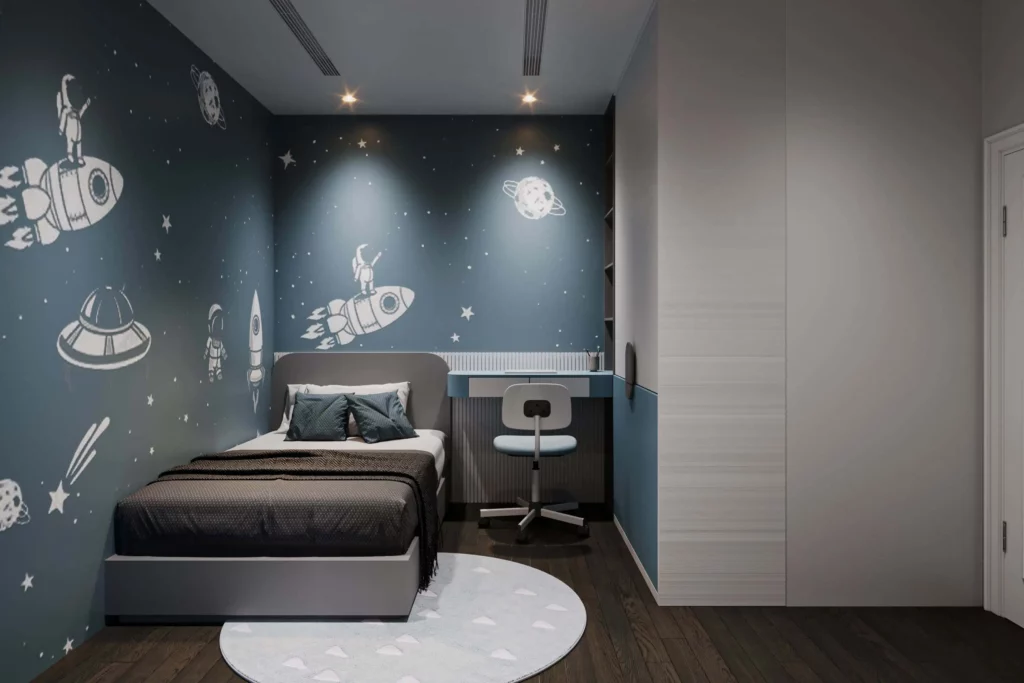 Imagem de um quarto de menino com papel de parede de foguetes, planetas e astronautas. O quarto tem uma cama de solteiro, travesseiros, um tapete redondo, uma escrivaninha com uma cadeira e piso de madeira escura