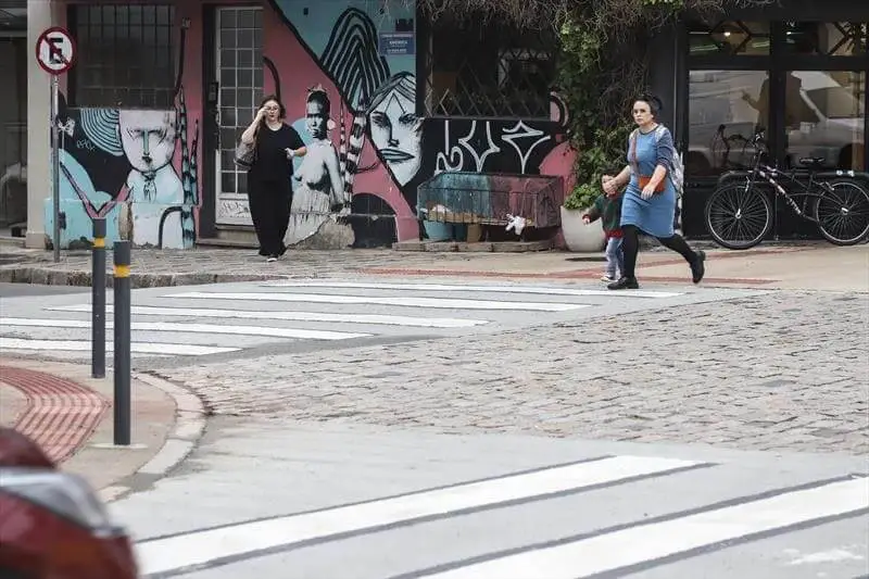 Imagem de uma pessoa atravessando uma faixa de pedestres na Alameda Prudente de Moraes, em Curitiba